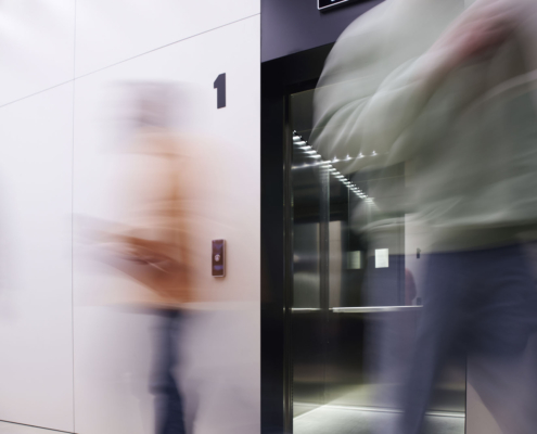 long exposure of business people walking near elevator with open