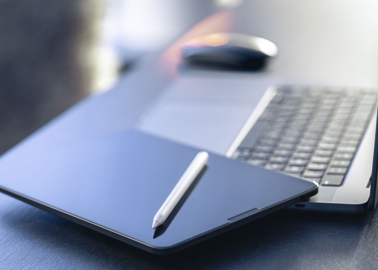 Digital tablet, stylus pen and laptop on the desktop, close up.